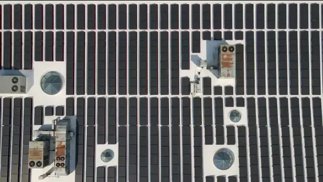 Still from the ROSE film for Industrial and Logistics: an aerial of a distribution warehouse roof carrying a full panel array.